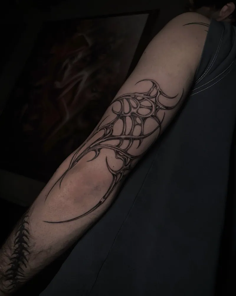 Tatuaggio astratto nero sull’avambraccio, con curve intrecciate e spazio negativo tra le linee